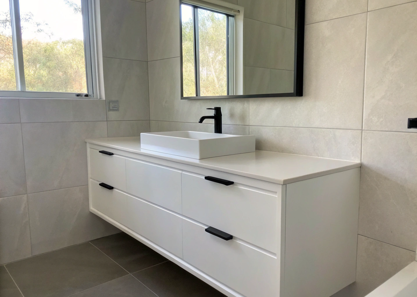 wall-hung-vanity-installation-wollongong Wall-hung vanity installation in a Wollongong bathroom with matte black tapware and large-format tiles